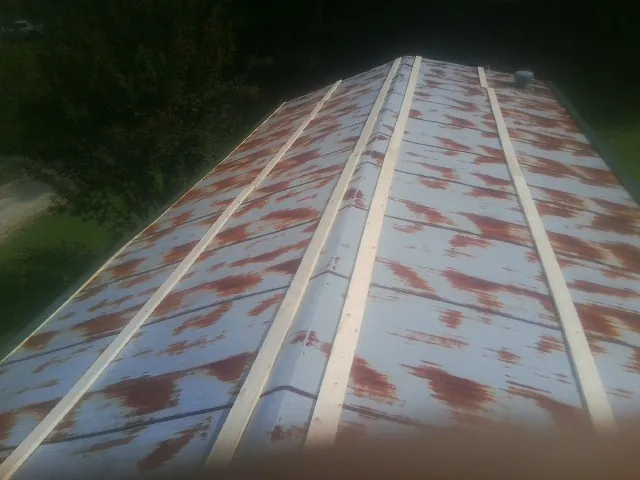 Rusted metal roof panels with new wood purlins before replacement — Storm Damage Roof Repair in Thor by Roofing Brothers
