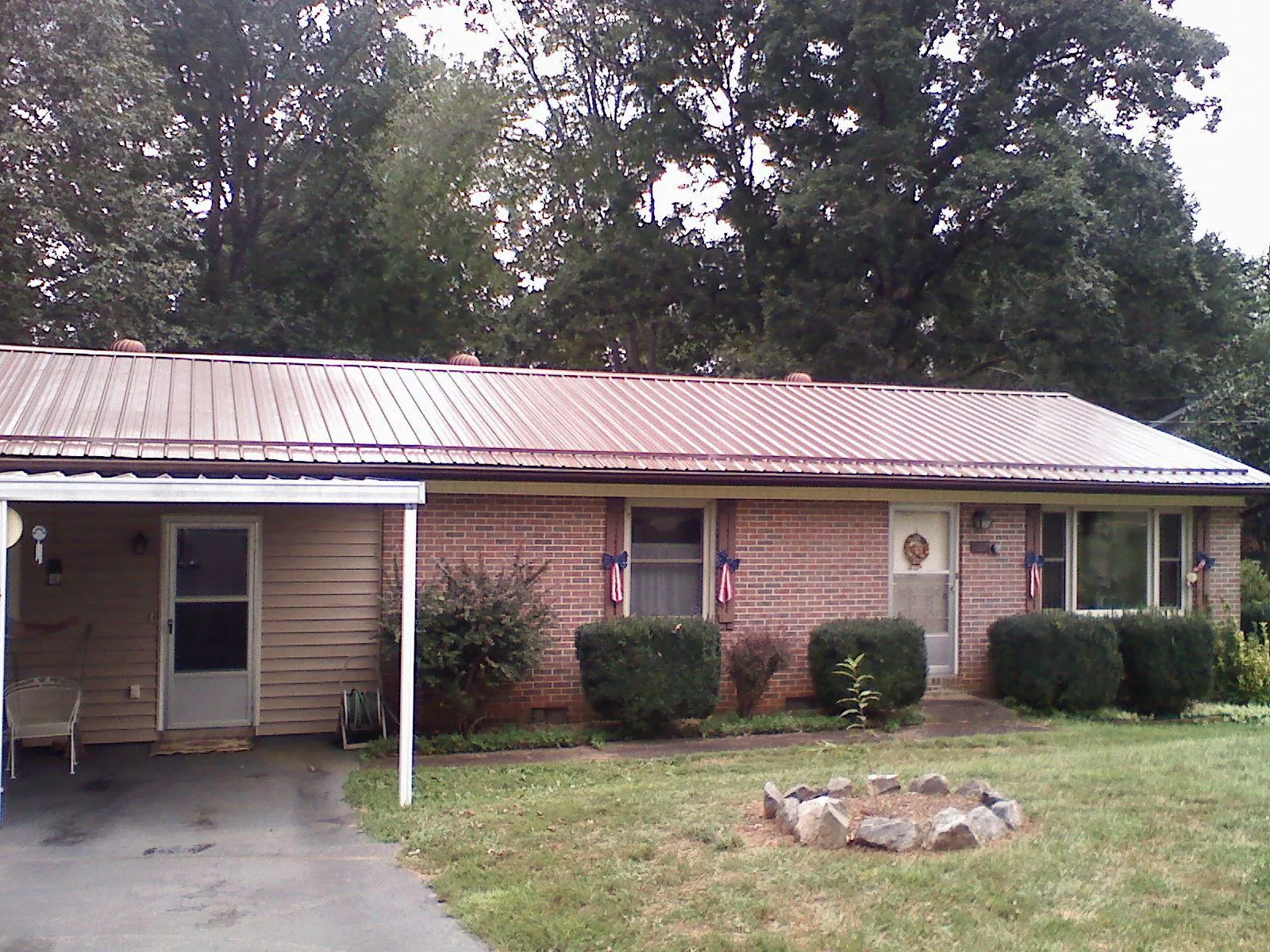 Bronze metal roof and carport on a brick ranch home — Roof Repair work by our crew in Thor