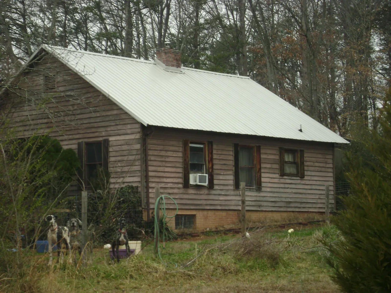 White metal roof on an old wood sided farmhouse, from a Metal Roof Installation job in Thor